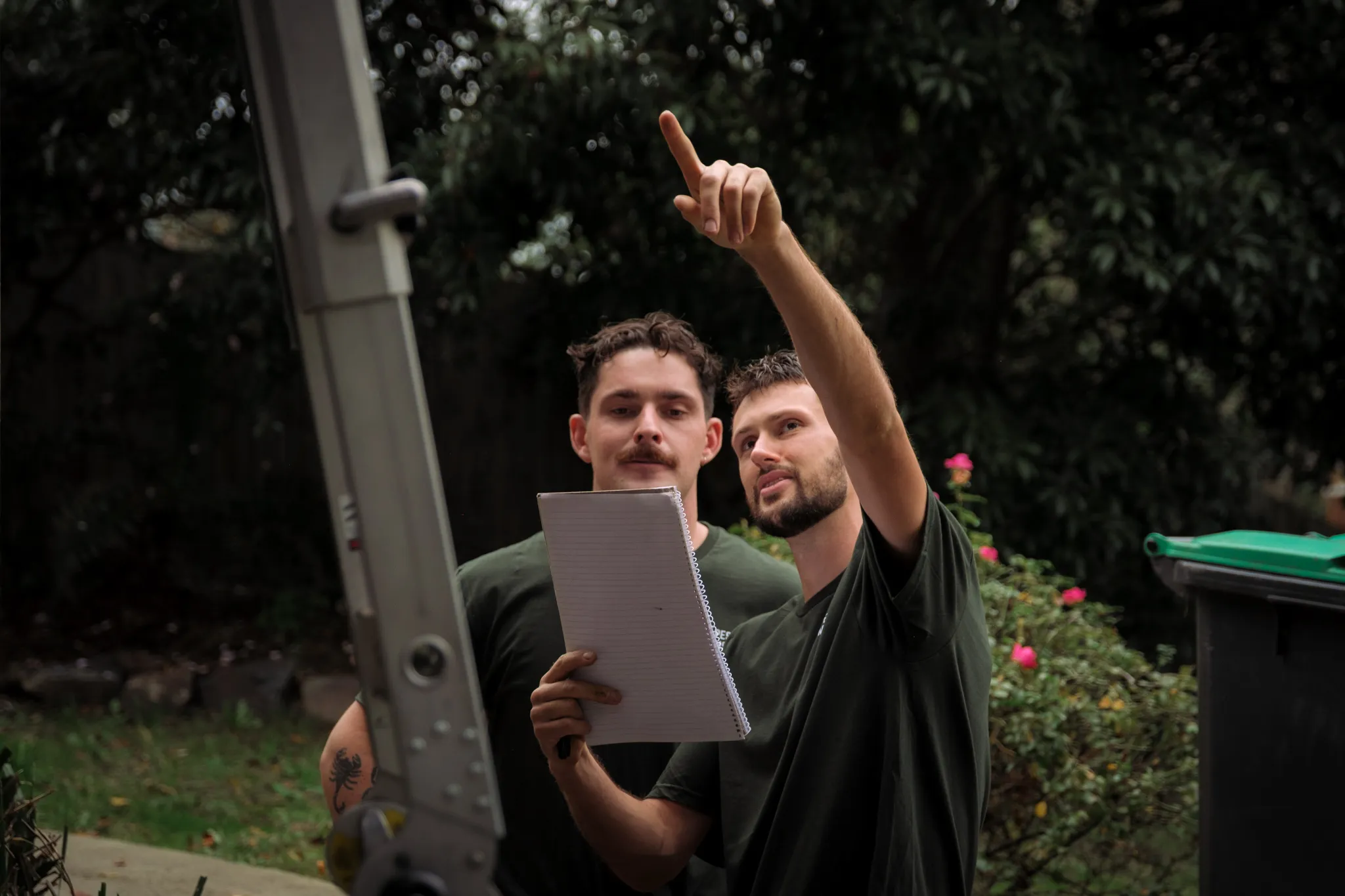 Two technicians inspecting a home exterior